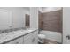Bathroom with granite countertop, white cabinets, and a shower/tub combo at 40630 E Eighth Ave, Umatilla, FL 32784