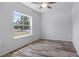 Bright bedroom with wood-look floors and large window at 40630 E Eighth Ave, Umatilla, FL 32784