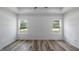Spacious bedroom with two windows, wood-look floors, and recessed lighting at 40630 E Eighth Ave, Umatilla, FL 32784