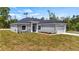Single-story home with gray siding, stone accents, and a two-car garage at 40630 E Eighth Ave, Umatilla, FL 32784