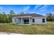Single-story home with covered patio, gray exterior, and a grassy backyard at 40630 E Eighth Ave, Umatilla, FL 32784