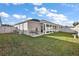 Spacious backyard with grassy lawn, screened porch, and privacy fence at 4414 Cameo Cir, The Villages, FL 32163