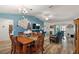Open living room and dining area with teal sofas, hardwood floors, and a view into the kitchen at 4414 Cameo Cir, The Villages, FL 32163