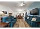 Spacious living room with teal sofas, hardwood floors, and a view of the dining area at 4414 Cameo Cir, The Villages, FL 32163