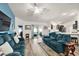 Bright living room with teal sofas, hardwood floors, and sliding glass doors leading to the patio at 4414 Cameo Cir, The Villages, FL 32163