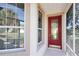 Front entrance with a red door and sidelights, screened porch at 5107 Aurora Dr, Leesburg, FL 34748