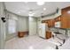 Kitchen with wood cabinets, white appliances, and tile flooring at 5107 Aurora Dr, Leesburg, FL 34748