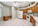 Kitchen with wood cabinets, white appliances, and tile flooring at 5107 Aurora Dr, Leesburg, FL 34748