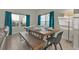 Dining area with wooden table, bench, and teal curtains at 840 Pebble Beach Dr, Davenport, FL 33896