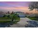 Two-story house with a gray exterior, white garage door, and landscaping at dusk at 1087 Welch Hill Cir, Apopka, FL 32712