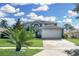 Two-story house with a gray exterior, white garage door, and landscaping at 1087 Welch Hill Cir, Apopka, FL 32712