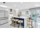 Modern kitchen with white cabinets, blue island, gold barstools, and pool view at 1087 Welch Hill Cir, Apopka, FL 32712