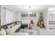 Living room features sectional sofa, coffee table, decorated tree, and open concept to kitchen at 1087 Welch Hill Cir, Apopka, FL 32712