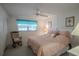 Cozy bedroom with large bed, rocking chair, ceiling fan, and window with bright valance at 110 N Tremain St # 110, Mount Dora, FL 32757
