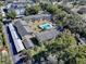 Aerial view of the community, including the pool, surrounding trees, and nearby buildings at 110 N Tremain St # 110, Mount Dora, FL 32757