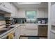 Bright kitchen featuring white cabinets, blue tiled backsplash, and stainless steel appliances at 110 N Tremain St # 110, Mount Dora, FL 32757