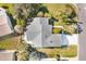 Aerial view of single-story home with gray roof, showcasing landscaping and driveway at 1201 De La Fuente Ct, The Villages, FL 32162