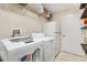 Laundry room with washer, dryer, shelving, and refrigerator at 1201 De La Fuente Ct, The Villages, FL 32162