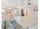 Spacious living room with tile floors and kitchen access at 1201 De La Fuente Ct, The Villages, FL 32162