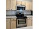 Well-equipped kitchen with stainless steel appliances, light wood cabinets, and a tile backsplash at 420 Summit Ridge Pl # 214, Longwood, FL 32779