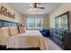 King-size bed, large dresser, and ceiling fan in this bedroom at 545 Kistler Cir, Clermont, FL 34715