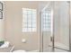 Well-lit bathroom with a shower, glass block window, and neutral colors at 973 Belle Oak Dr, Leesburg, FL 34748