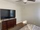 Bedroom with large TV and wood flooring at 9785 Pepper Tree Trl, Wildwood, FL 34785