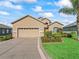 Two-story home with a two-car garage, landscaped yard, and palm tree at 11075 Se 173Rd Pl, Summerfield, FL 34491