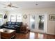 Sunlit living room with leather sofa and sliding glass doors at 1443 Greenville Way, The Villages, FL 32162
