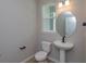 Clean bathroom with pedestal sink, toilet, and round mirror at 16436 Hamlin View St, Winter Garden, FL 34787