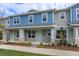 Two-story townhome with blue and gray siding, stone accents, and a front porch at 16436 Hamlin View St, Winter Garden, FL 34787