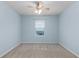 Simple bedroom with light blue walls, ceiling fan, and window at 1724 Point O Woods Ct, Mount Dora, FL 32757