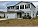 Two-story house with gray siding, black shutters, and a white garage door at 209 Hyacinth Ct, Kissimmee, FL 34759