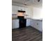 White shaker cabinets, black appliances and gray flooring in this modern kitchen at 209 Hyacinth Ct, Kissimmee, FL 34759