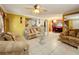 Spacious living room with tiled floors, neutral colored couches, and a ceiling fan at 316 Amanda Ln, Leesburg, FL 34748