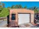 Tan storage shed with a roll-up door and a window at 316 Amanda Ln, Leesburg, FL 34748