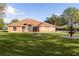 Orange house with a fountain and lush green lawn at 324 Tomato Hill Rd, Leesburg, FL 34748