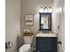 Elegant powder room with navy vanity, granite countertop, and decorative accents at 36438 N County Road 44A, Eustis, FL 32736