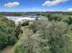 Lakefront property with lush trees and a clear sky at 4235 Dove Valley Ln, Lady Lake, FL 32159