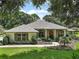 One-story home with gray roof,red door,landscaped yard, and walkway at 6147 Spinnaker Loop, Lady Lake, FL 32159