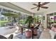 Spacious screened patio with ample seating and lush greenery at 6147 Spinnaker Loop, Lady Lake, FL 32159