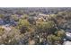 Aerial view showing a house's setting in a residential area with mature trees at 708 Dennis Ave, Fruitland Park, FL 34731