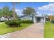 Light blue single story home with carport, palm trees, and manicured lawn at 727 Turnberry Ln, The Villages, FL 32159