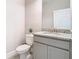 Powder room with granite countertop and gray vanity at 8512 Magnificent Ln, Groveland, FL 34736