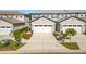 Front view of townhome with two-car garage and landscaped yard at 8512 Magnificent Ln, Groveland, FL 34736