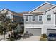 Gray two-story townhome, two-car garage, and nicely landscaped front yard at 9084 Shepton St, Orlando, FL 32825