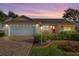 Attractive home at dusk with a white garage door and nicely landscaped yard at 941 Eastmont Ct, The Villages, FL 32162