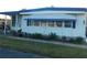 Mobile home with covered porch and attractive landscaping at 117 Hibiscus Way, Leesburg, FL 34748
