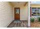 Front door entry with wood-look flooring and a welcoming mat at 1233 Carvello Dr, The Villages, FL 32162