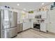 White kitchen with stainless steel appliances and wood flooring at 1233 Carvello Dr, The Villages, FL 32162